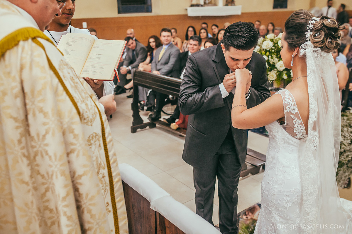 Noivo beijando as mãos da noiva
