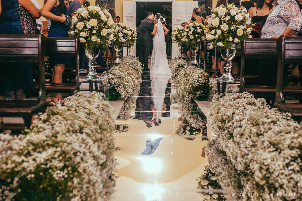 Noivos se beijando na saída do casamento