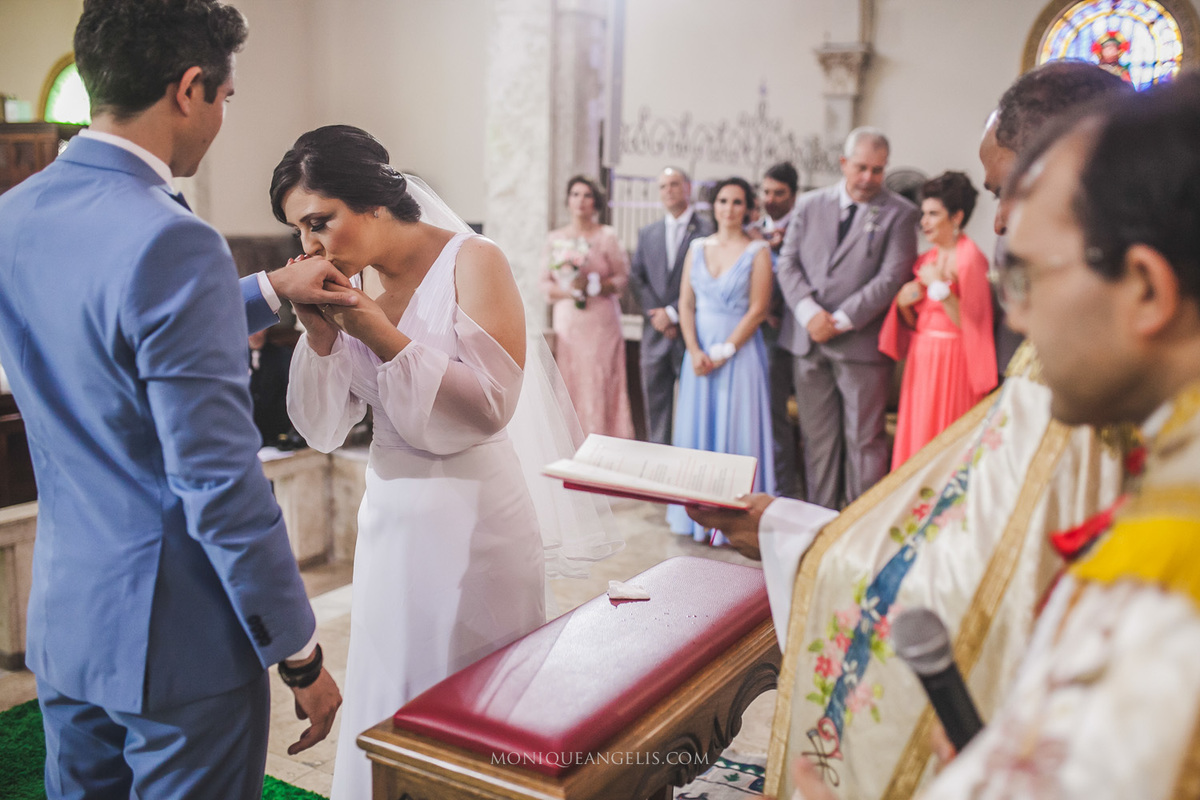 noiva beijando a aliança do noivo por Monique Angelis
