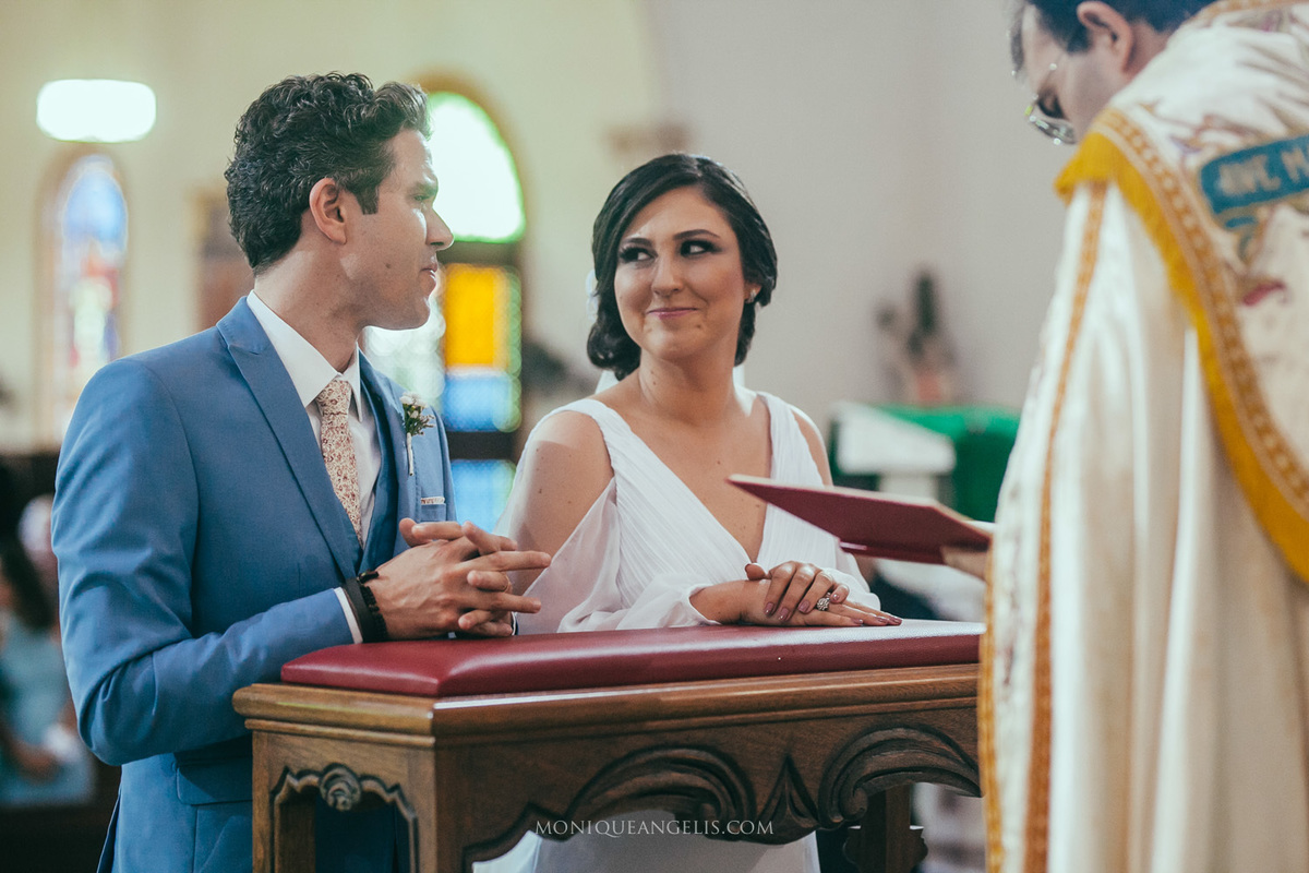 noiva trocando olhar com o noivo no altar por Monique Angelis