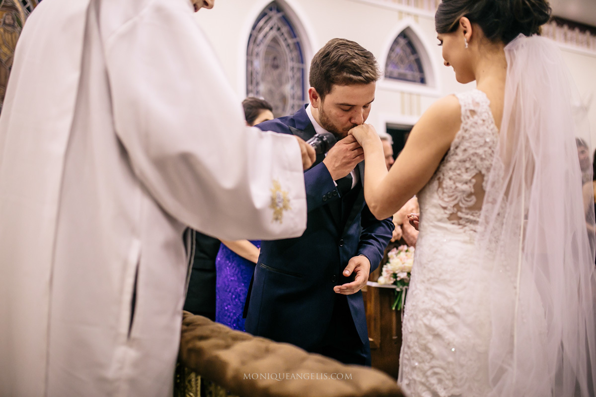 Noivo beija as mãos da noiva no altar