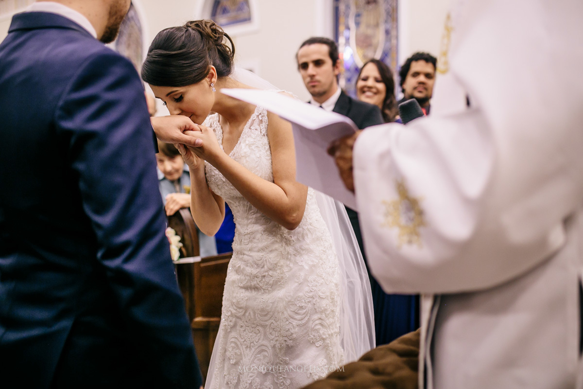 Noiva beija as mãos da noivo no altar