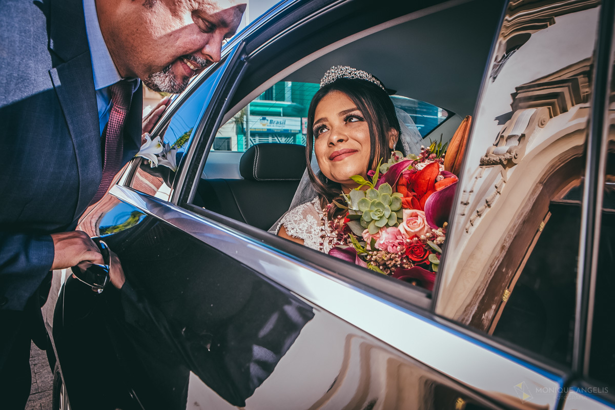 O pai da noiva recebendo a noiva no carro