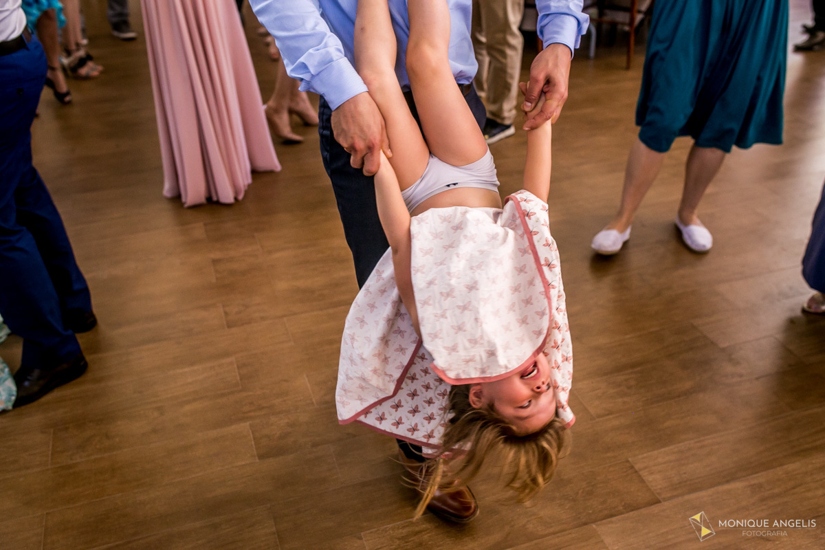 Menininha dançando e brincando com seu pai durante festa do casamento
