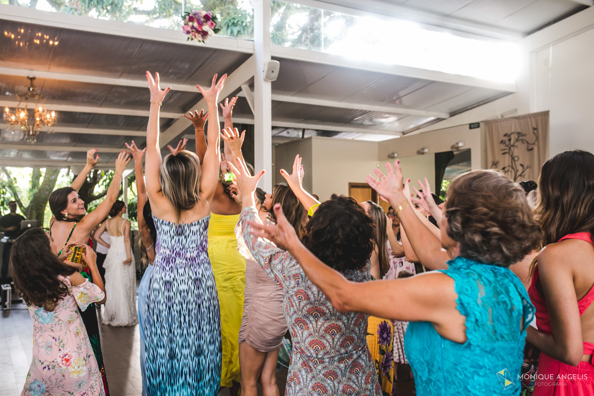 Noiva Joga o buquê para suas convidadas durante festa de casamento