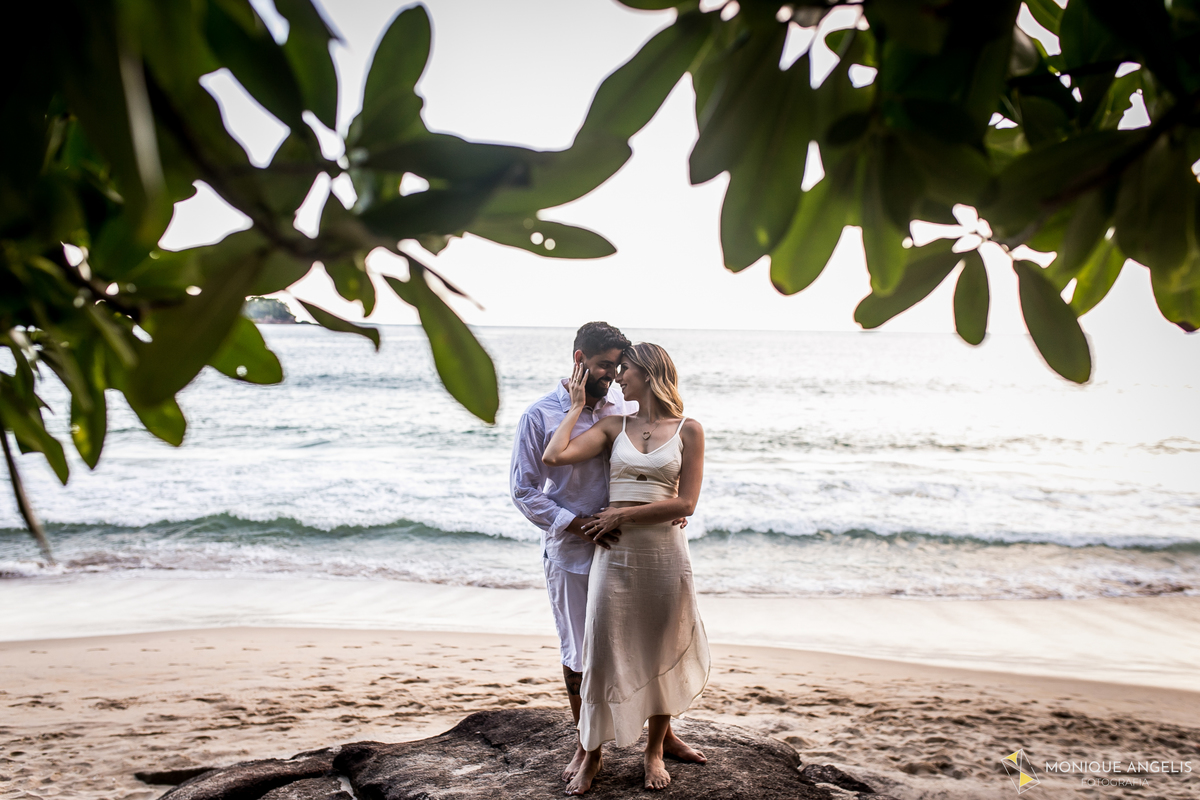 casal de noivos abraçados na areia em ensaio pré-wedding na praia