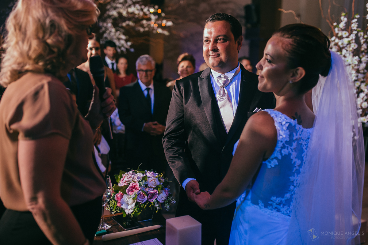 casal de noivos de mãos dada durante cerimônia de casamento