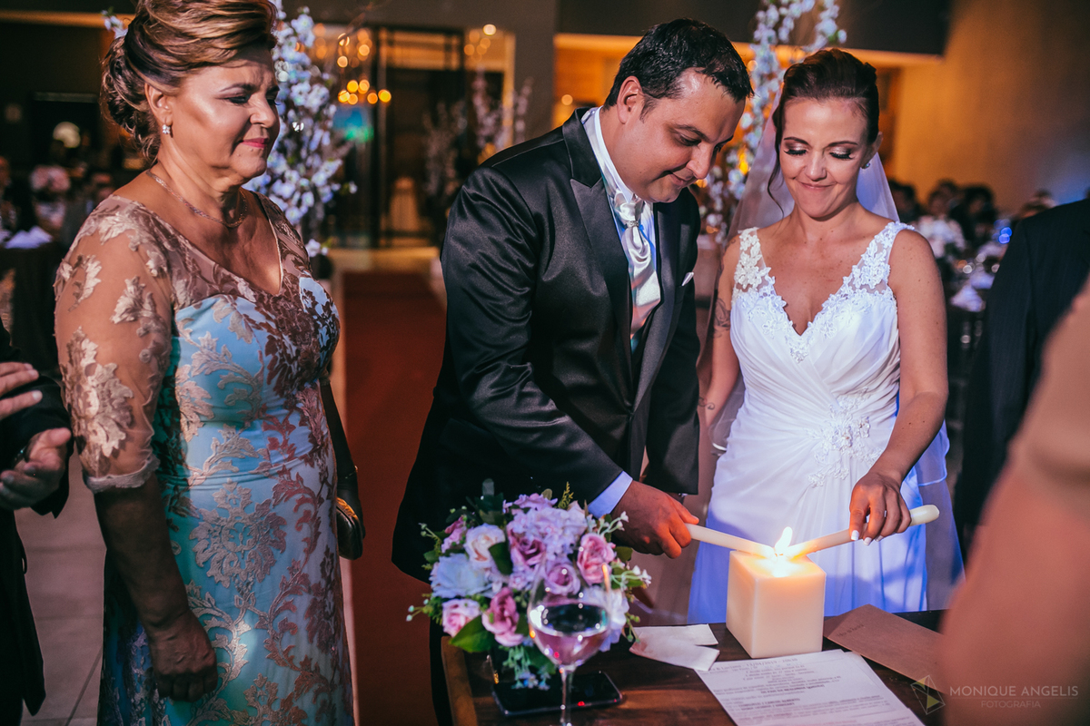 casal de noivos ascendem vela durante cerimônia de casamento