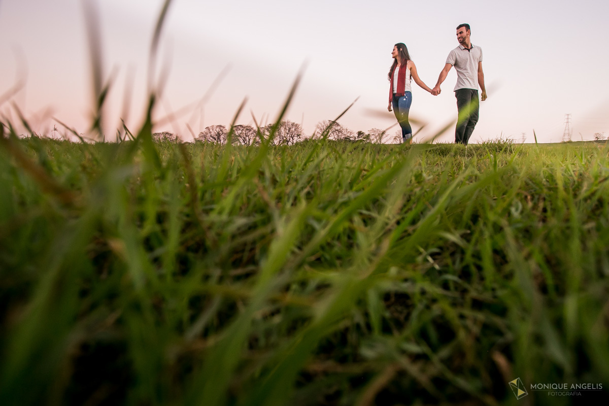 Fotos de casal de mãos dadas na grama em ensaio pré wedding na fazenda Quilombo Limeira