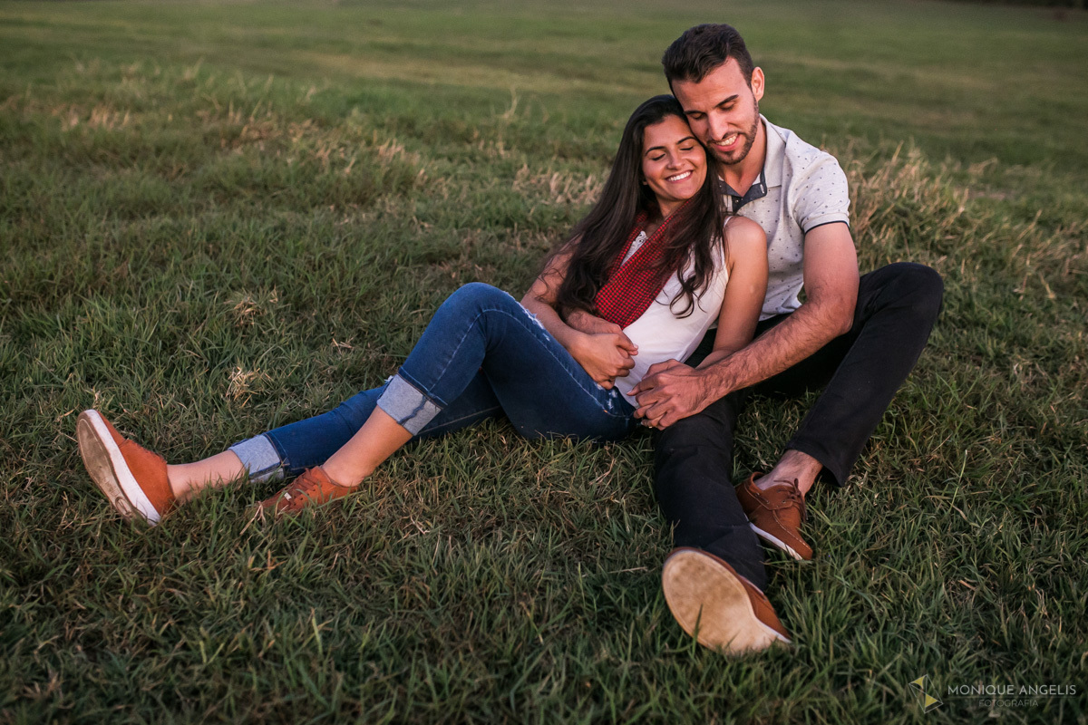 Foto de casal sentados na grama em ensaio pré wedding na fazenda Quilombo Limeira