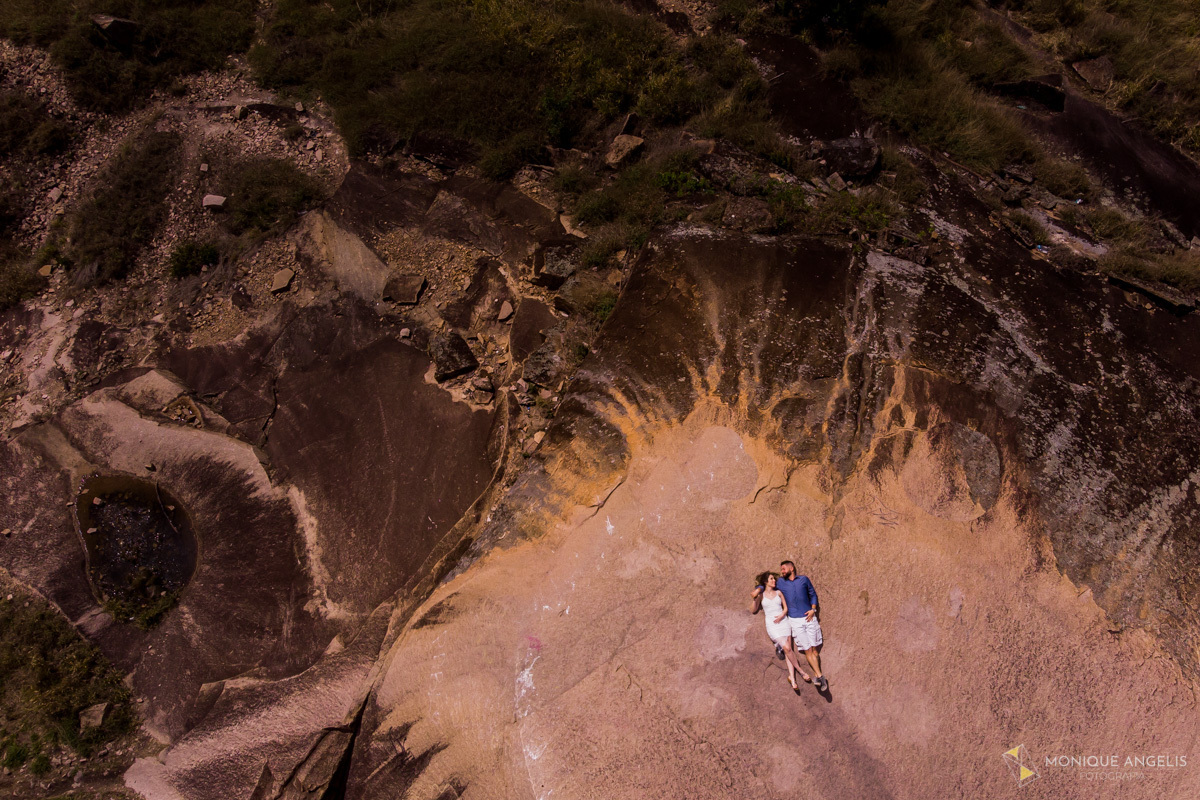 Foto aérea de casal de noivos deitados no chão