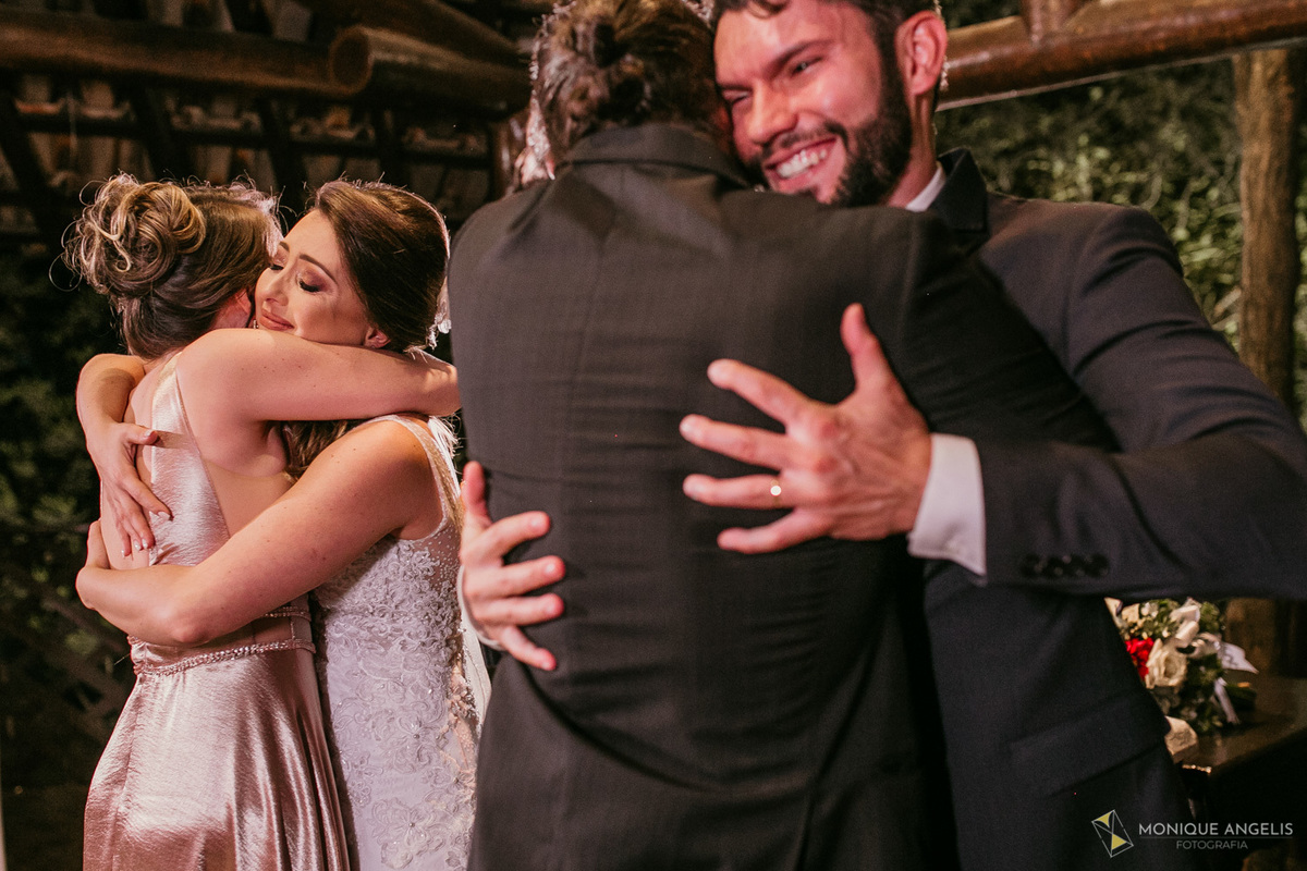 Casal de noivos emocionados recebem os cumprimentos dos padrinhos após a cerimônia de casamento no Kratos Eventos