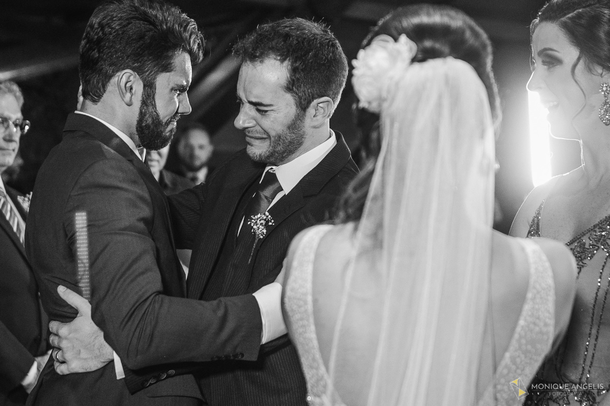 Casal de noivos emocionados recebem os cumprimentos dos padrinhos após a cerimônia de casamento no Kratos Eventos