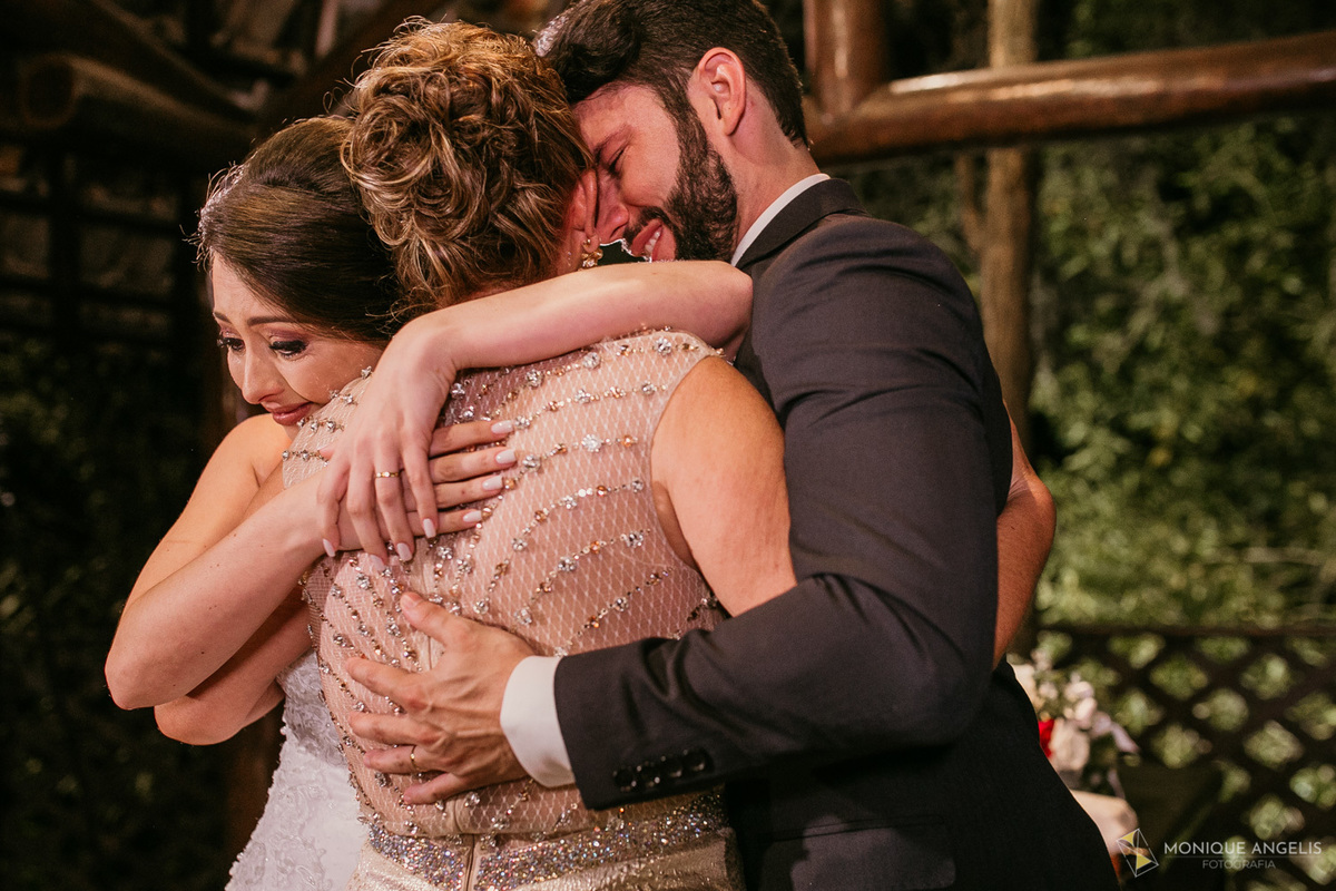 Casal de noivos emocionados recebem os cumprimentos dos padrinhos após a cerimônia de casamento no Kratos Eventos