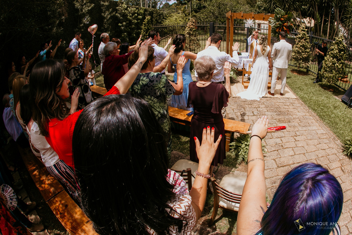 Convidados estendem as mãos ao casal de noivos na cerimônia de casamento na Chácara Vila Velha em Itatiba