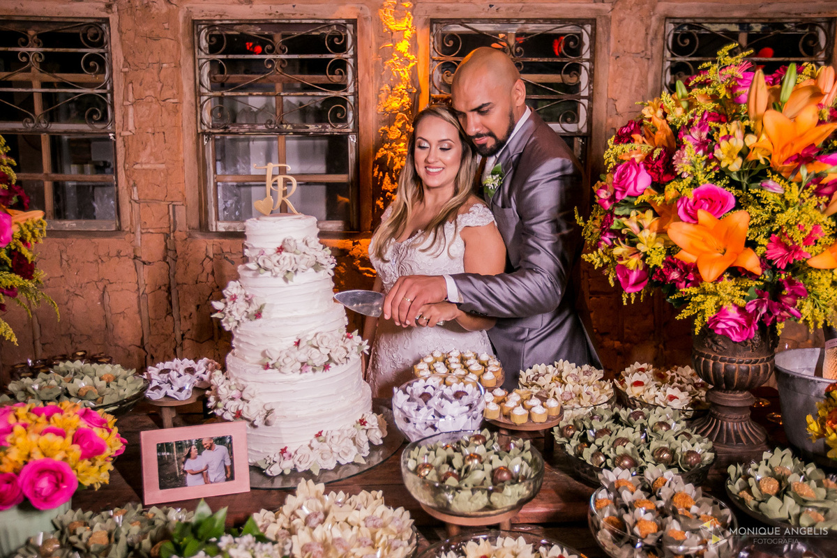 Casal de noivos cortando o bolo durante a recepção do casamento na Paioça do Caboclo Campinas SP