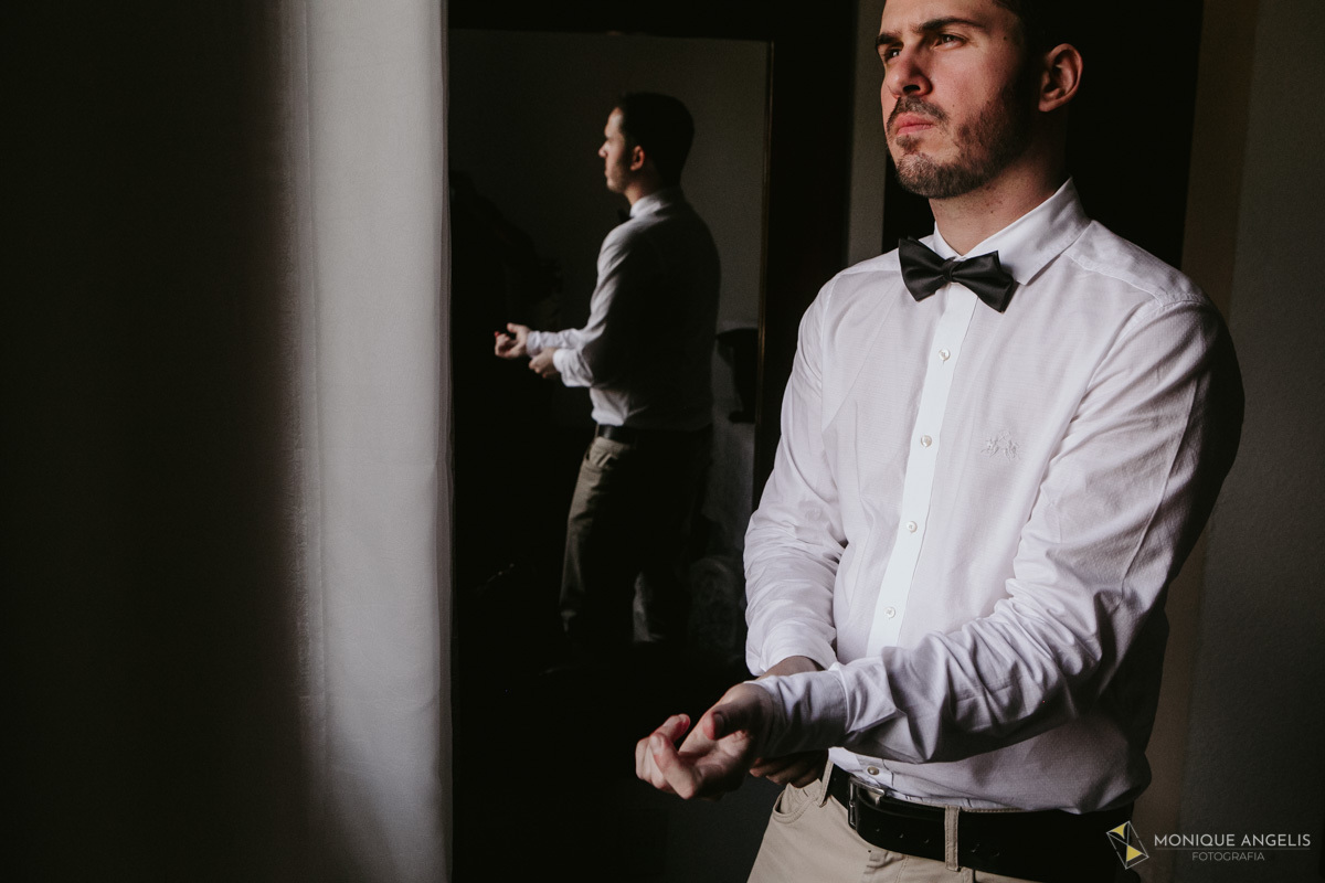 Noivo ajustando a manga em seu making of antes do casamento