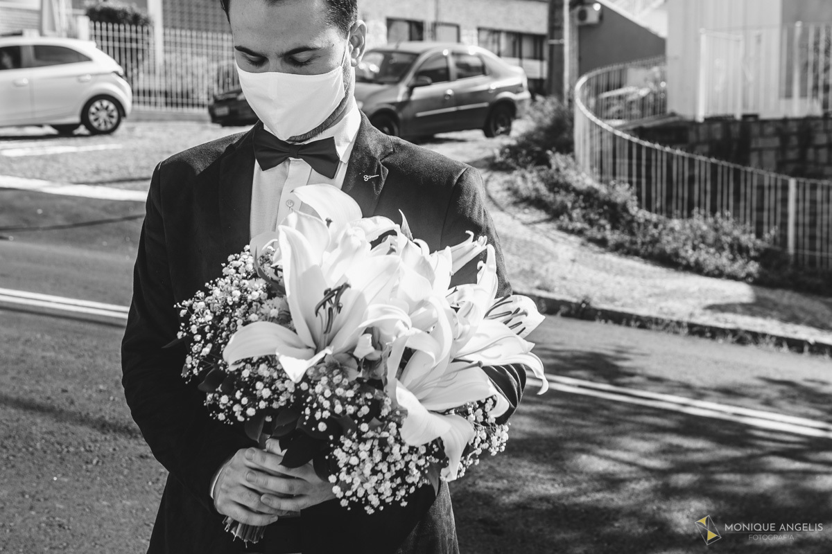 Noivo emocionado segurando o buquê antes da cerimônia civil de Casamento em Valinhos SP