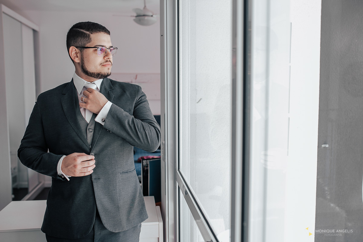 Noivo arrumando a gravata antes de ir para o casamento - Espaço Supremo - Monique Angelis Fotografia