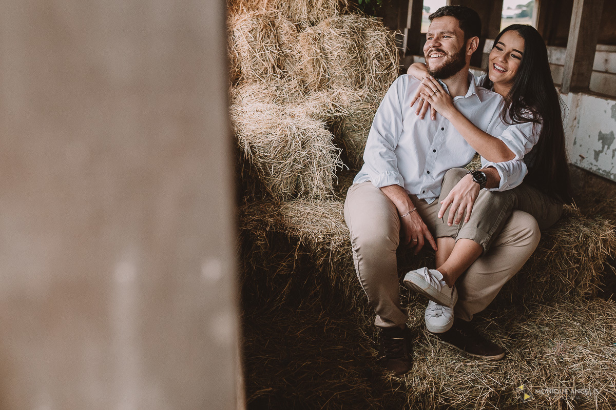 casal de noivos abraçados e sentado no feno em Holambra SP - Por Monique Angelis