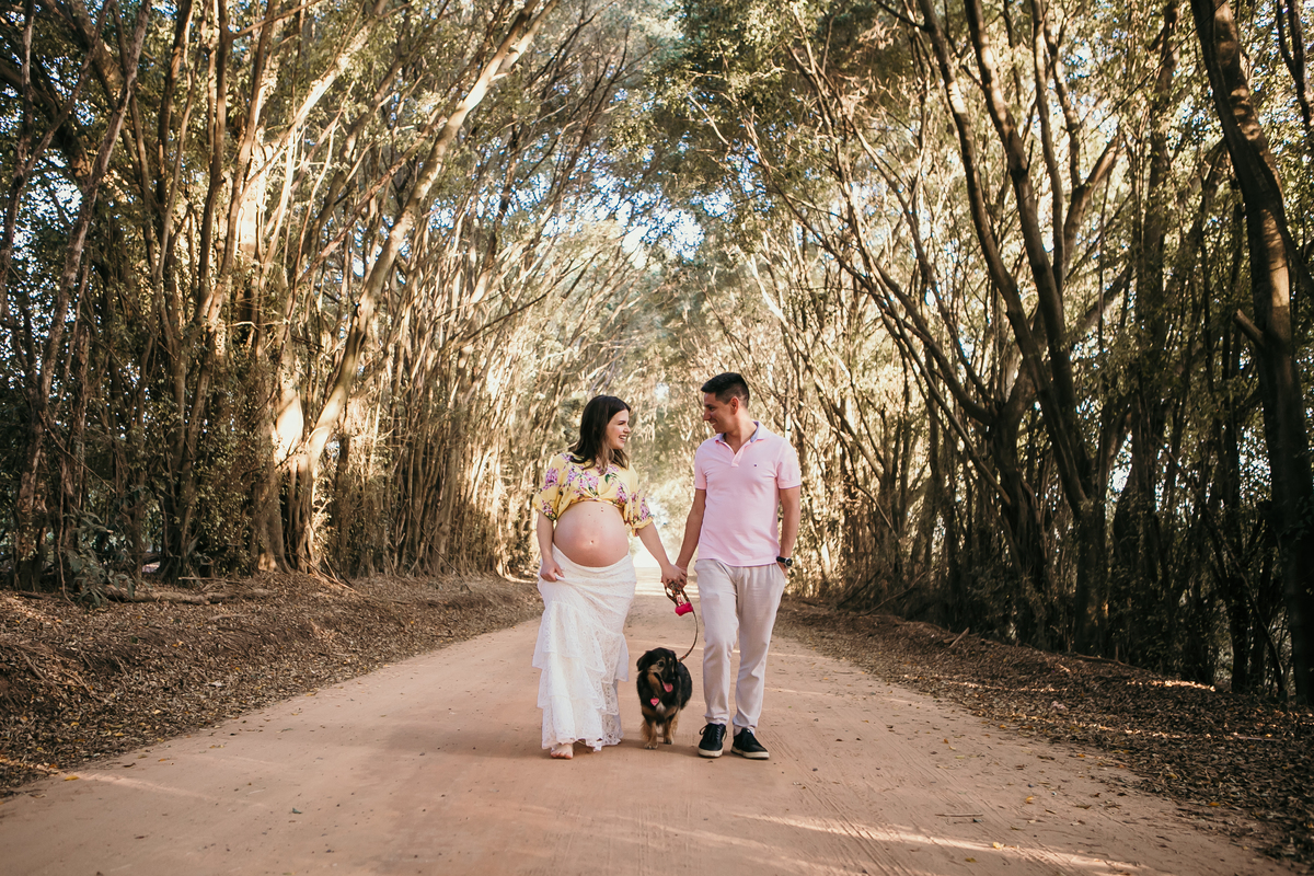 Casal de grávidos caminhando na estrada de terra