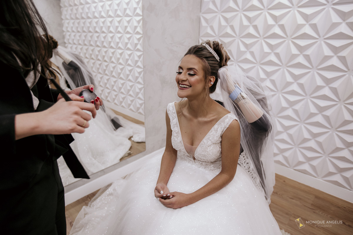 Noiva fazendo retoque de maquiagem antes da cerimônia de casamento