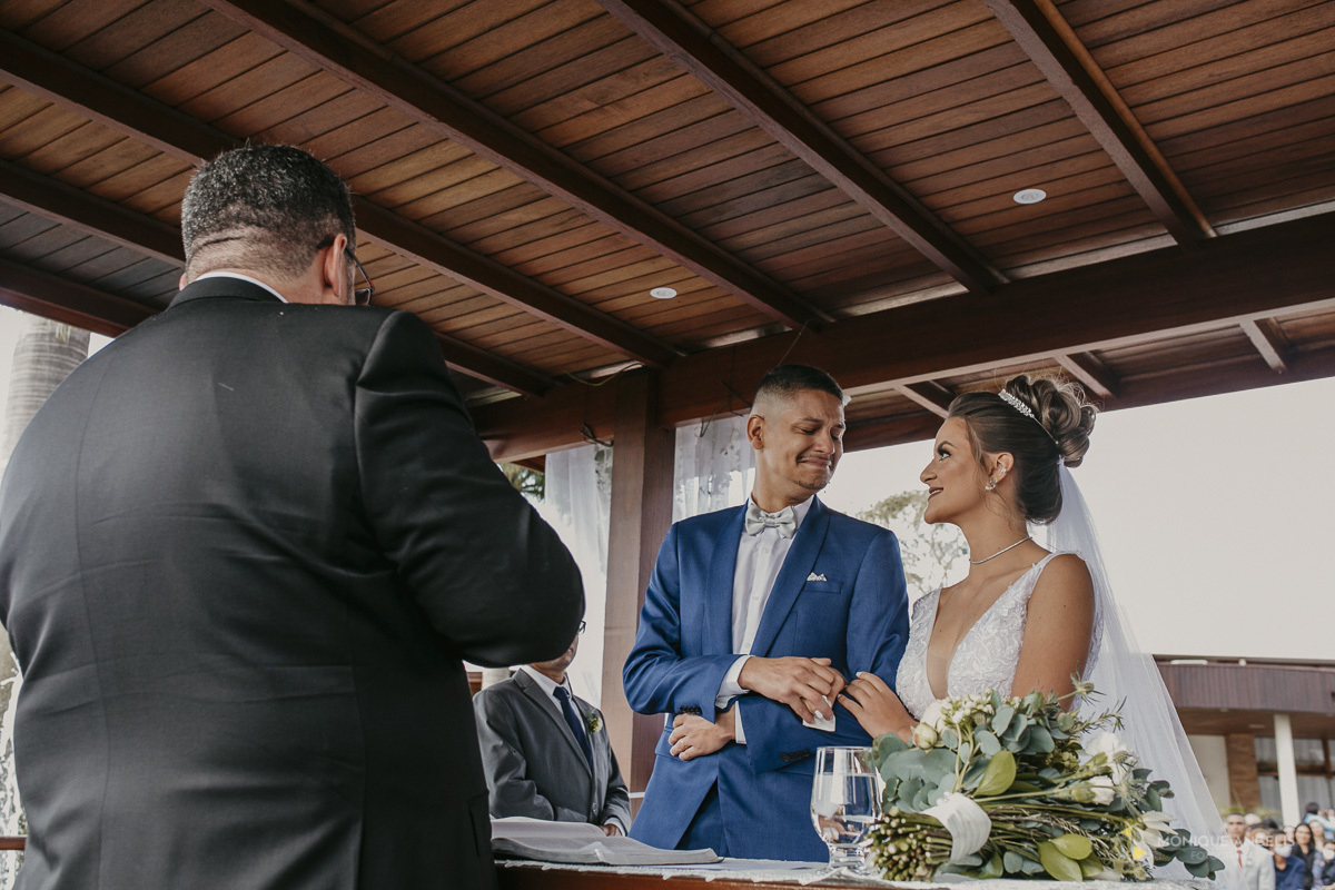 Casal de noivos trocando olhares durante a cerimônia de casamento no Villa Harmonia Eventos