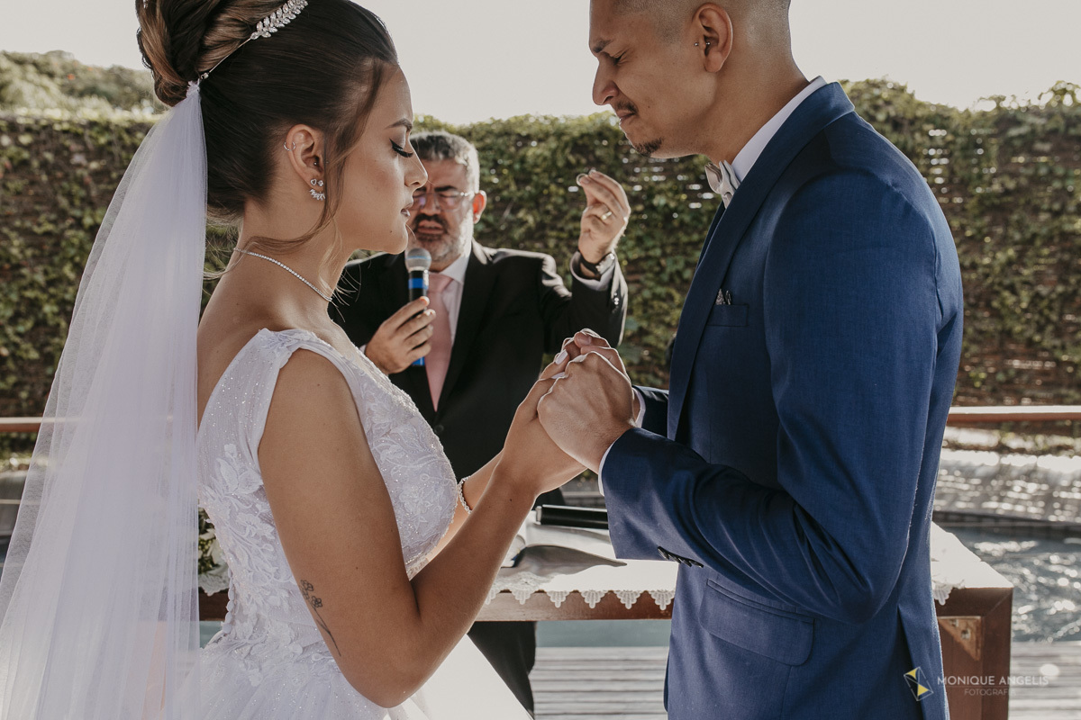 casal de noivos orando de mãos dadas durante a cerimônia de casamento no Villa Harmonia Eventos