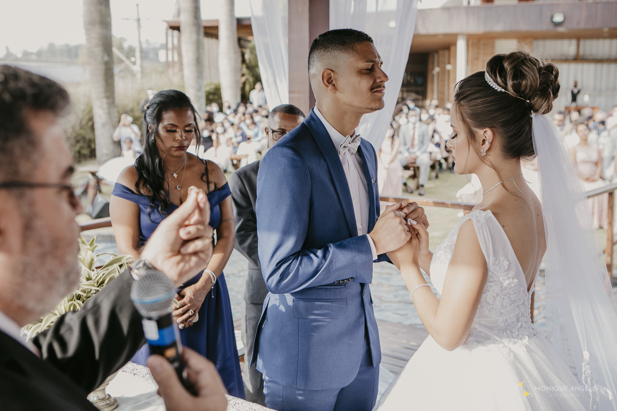 casal de noivos orando de mãos dadas durante a cerimônia de casamento no Villa Harmonia Eventos