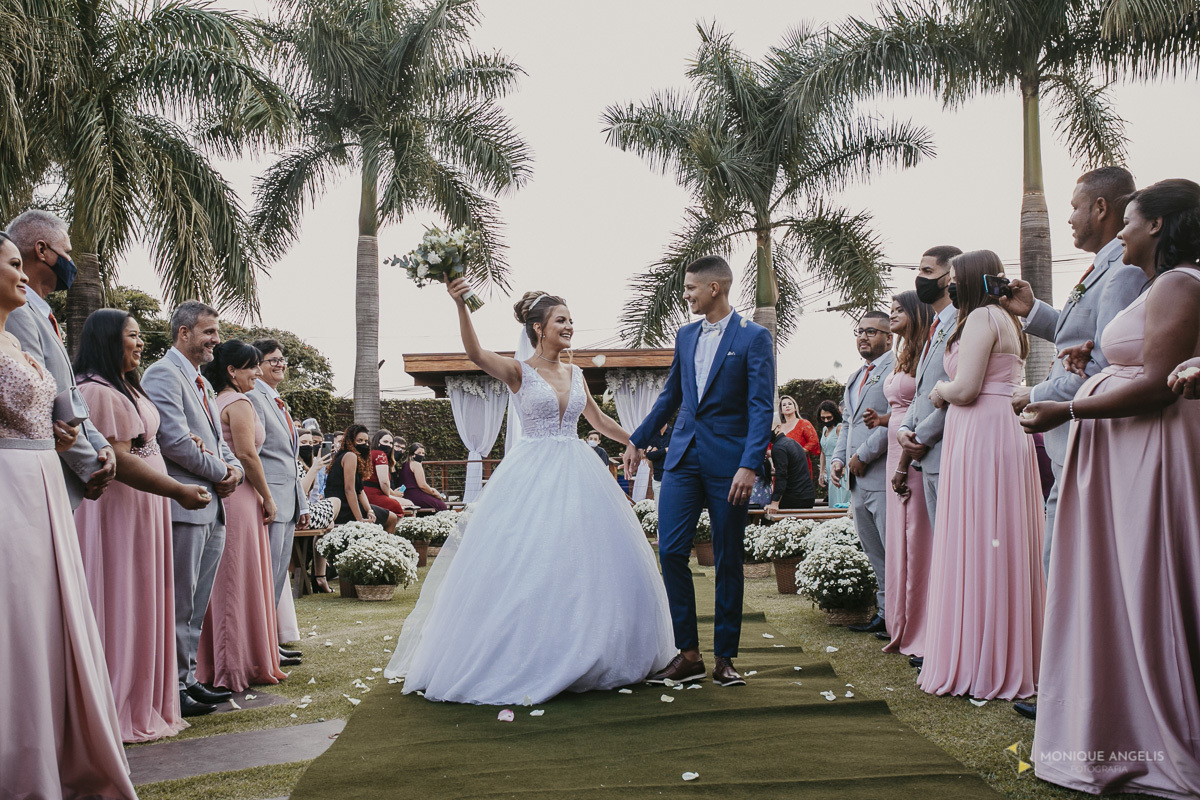 A saída do casal de noivos após a cerimônia de casamento no Villa Harmonia Eventos