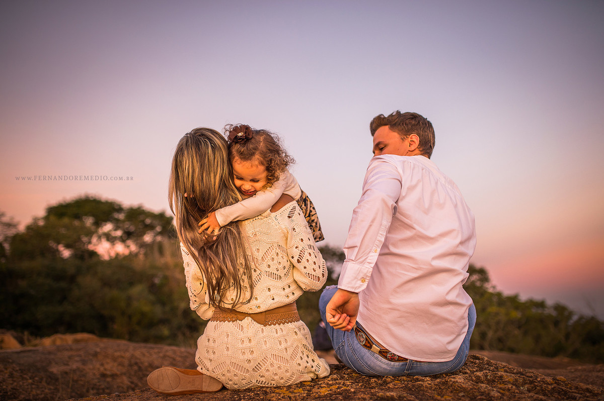Foto ensaio familia com os pais brincando com sua filha laurinha posando para o fotografo em campinas