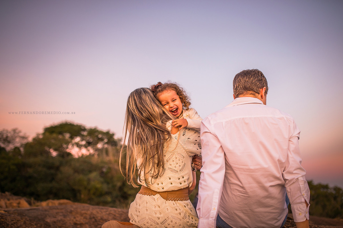 Foto ensaio fotografico familia com os pais brincando com sua filha laurinha sorrindo para o fotografo em campinas - sao paulo