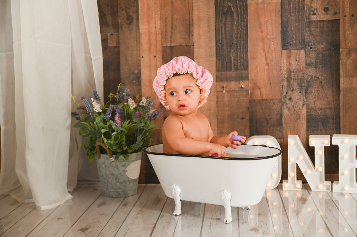 girl smash cake photo shoot wood background flowers tub 