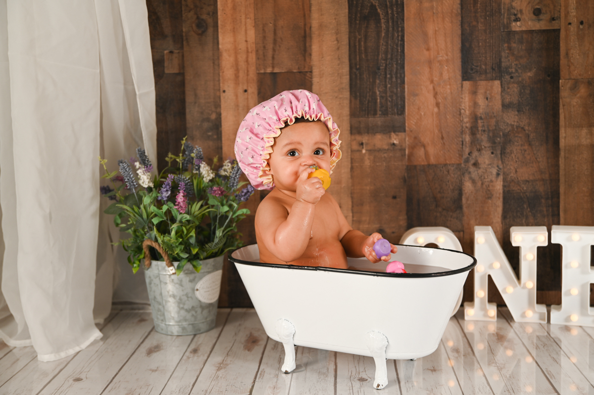 girl smash cake photo shoot wood background flowers tub 