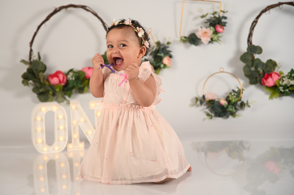 girl smash cake photo shoot white background flowers one