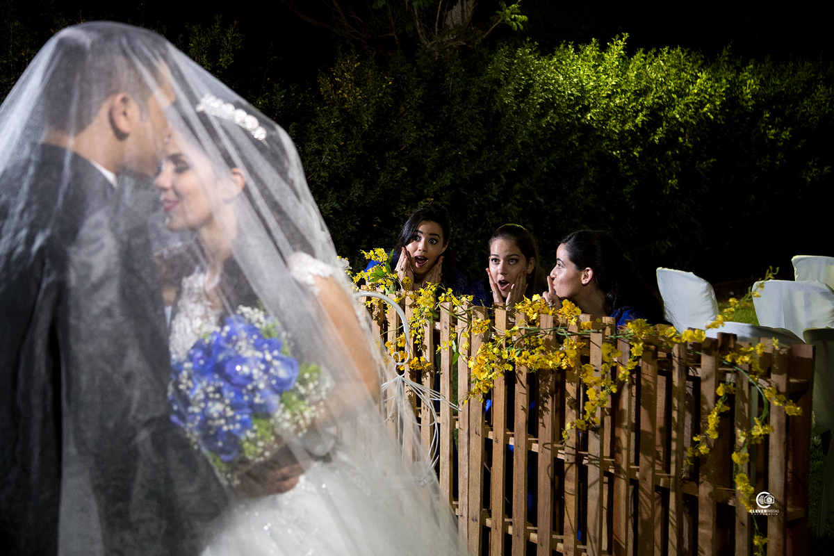 Damas de honra espiando o beijo dos noivos