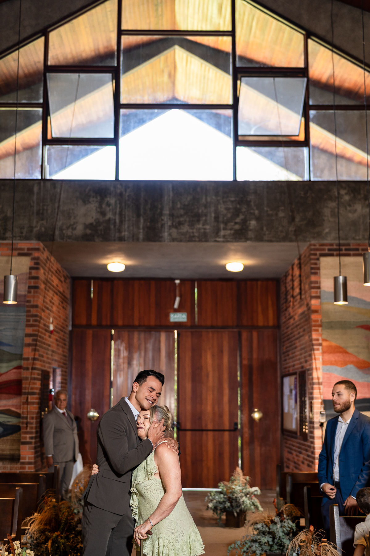 Foto que mostra total afeto entre mãe e filho, na entrada do noivo na igreja.