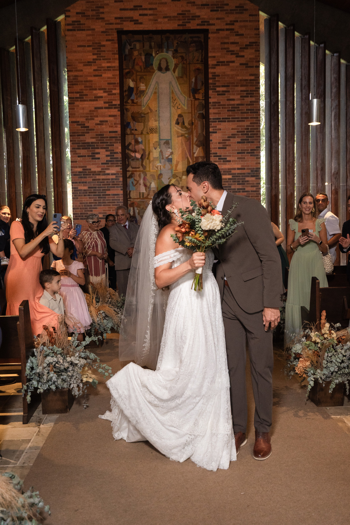 Foto que representa o grande finale, o beijo na saida dos noivos, para concretizar o amos deste casal.