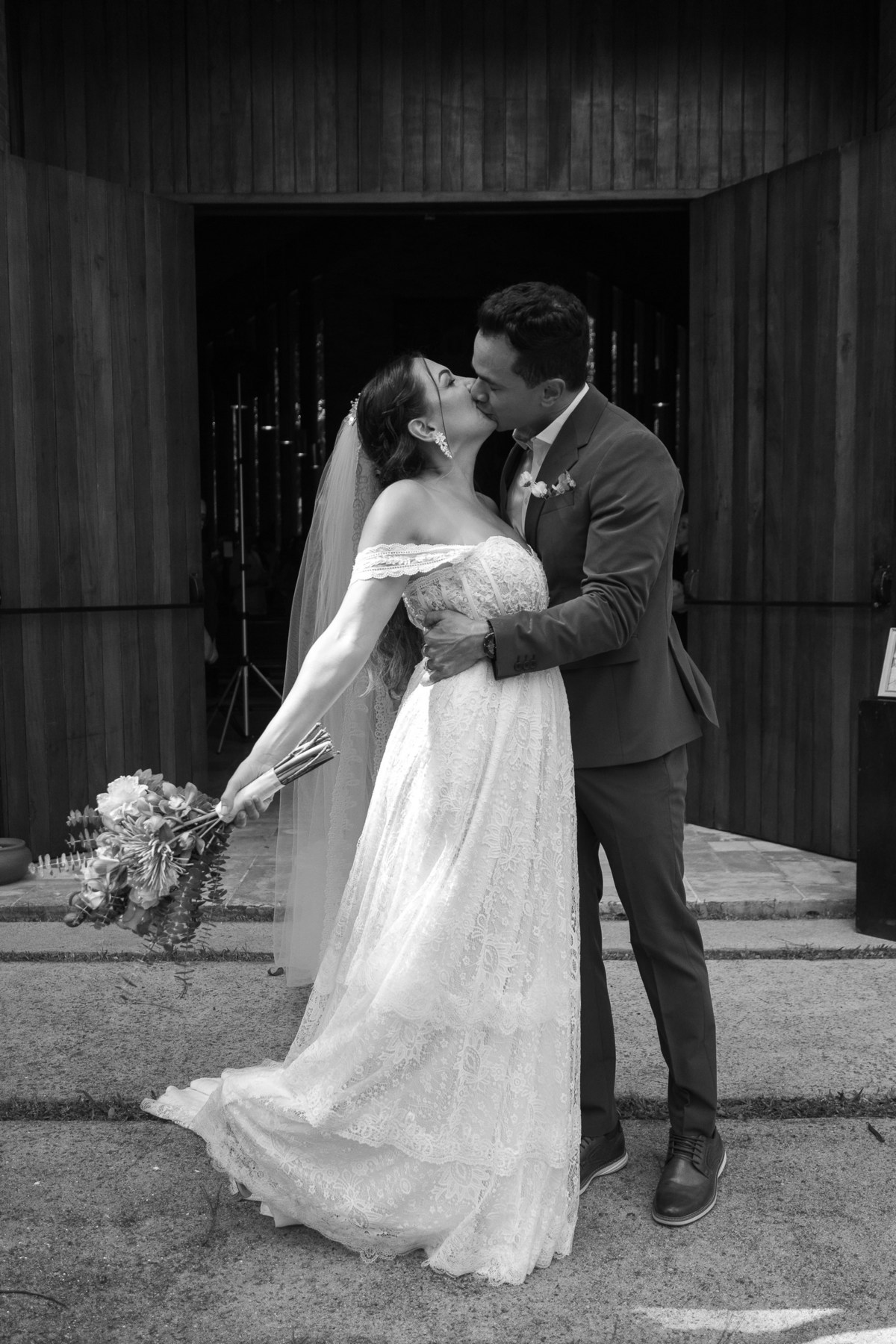 Foto de um beijão do mais novo casal, na faxada da igreja.