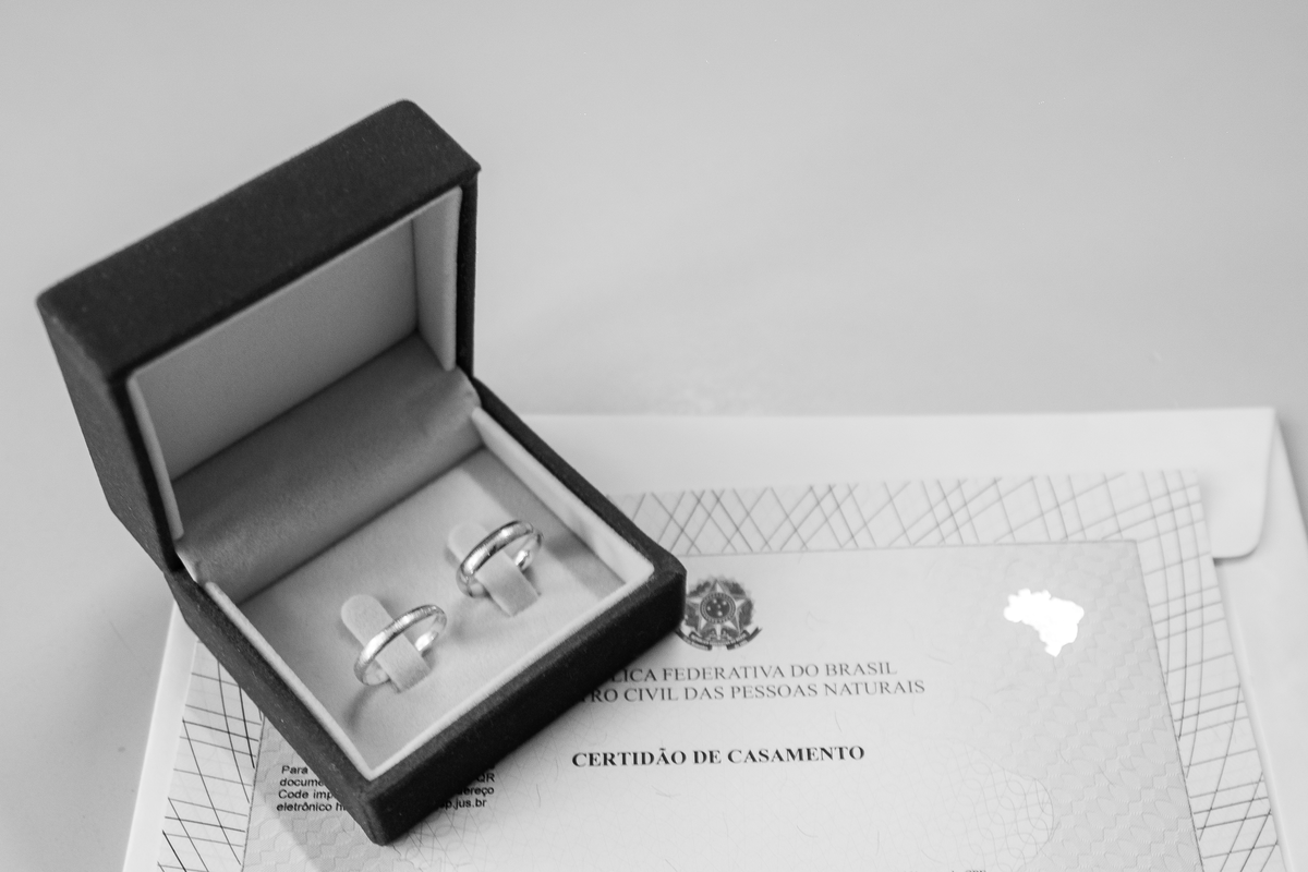 Foto still feita no registro do casamento civil no cartório, onde foi feita uma composição das alianças e o documento civil assinado.