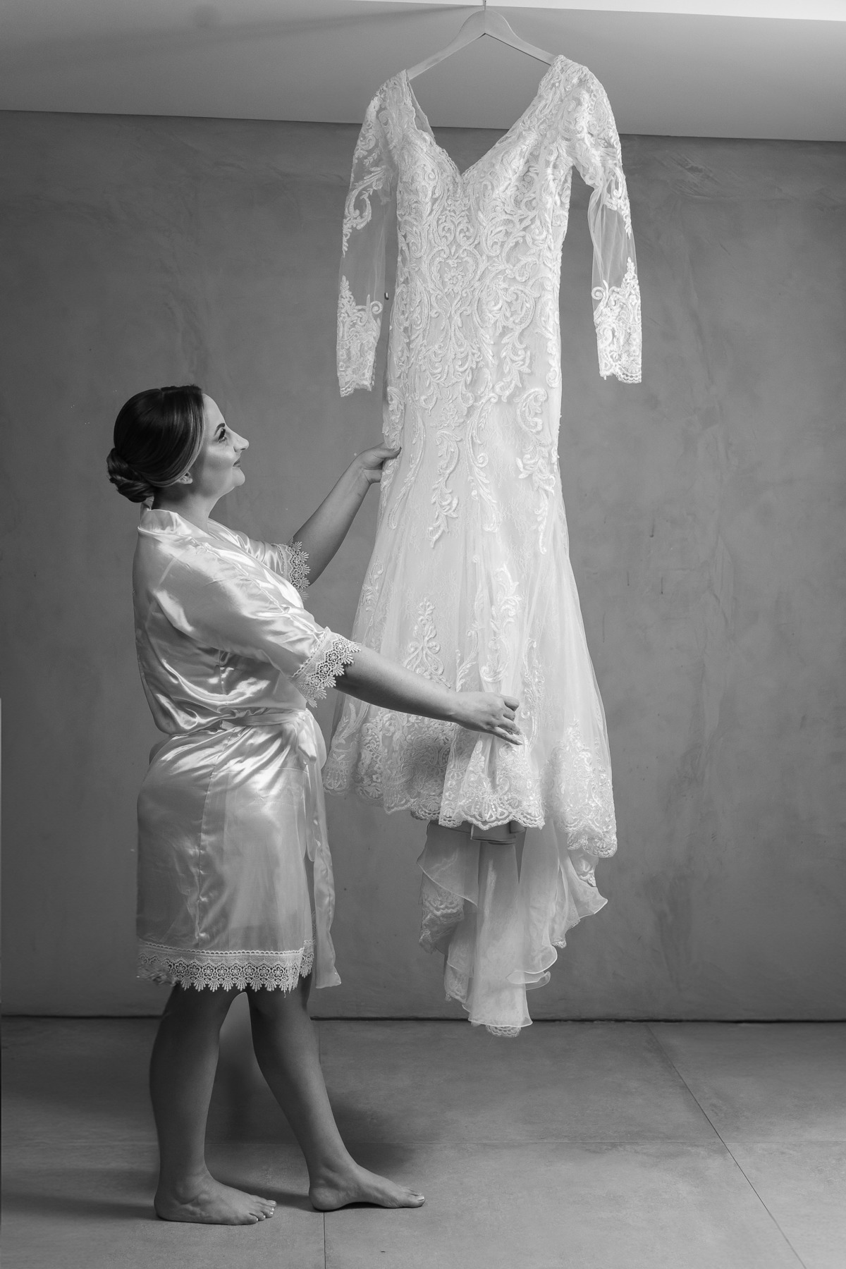 Foto feita no making of da noiva, onde ela admira o seu vestido.