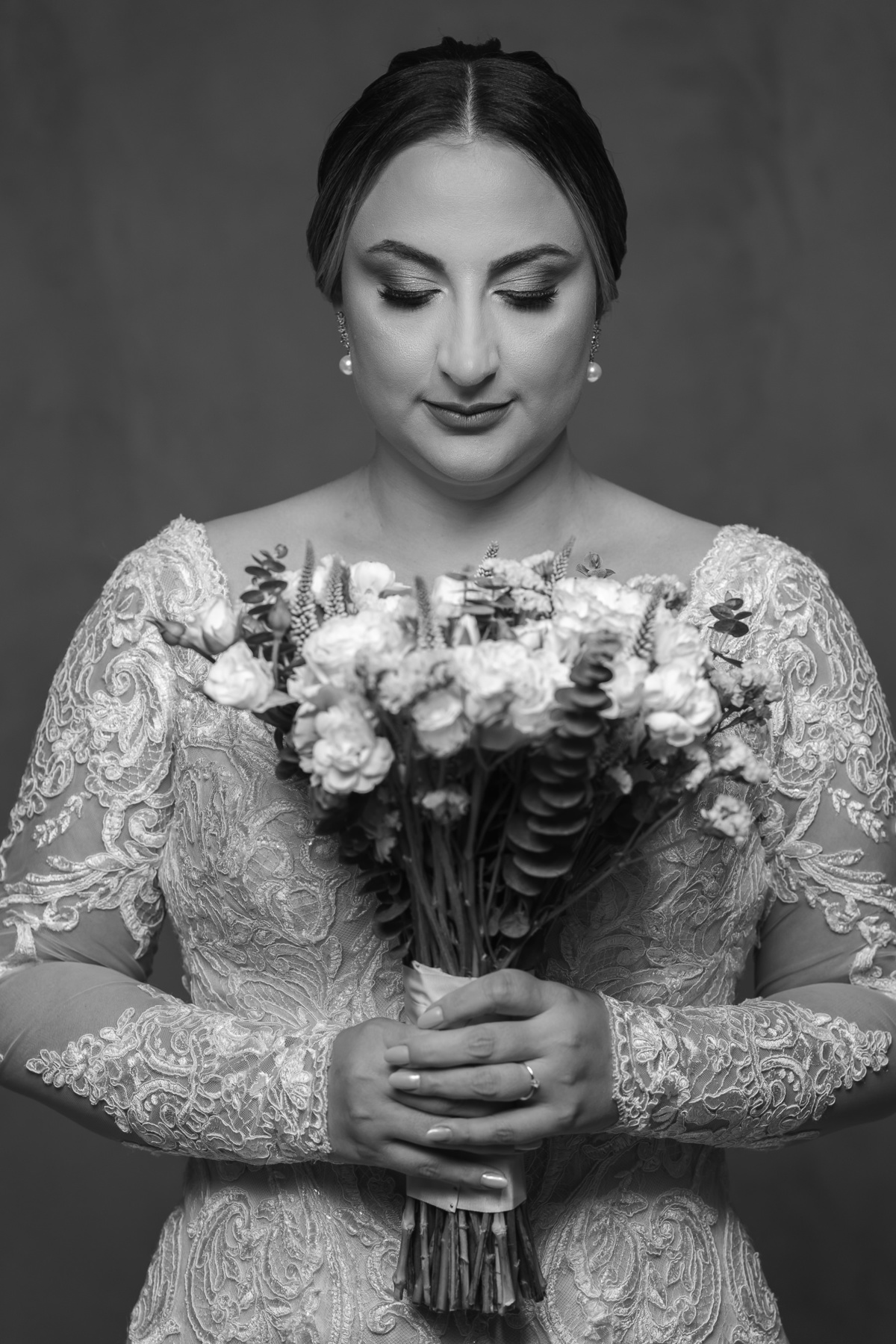 Foto da noiva admirando o seu buquê, pouco antes da cerimoônia de casamento.