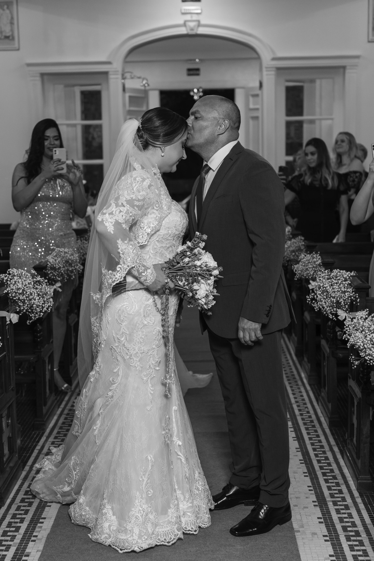 Foto que mostra o pai da noiva cumprimentando sua filha, instantes ante dela subrir no altar, e ser recepcionada pelo seu noivo.