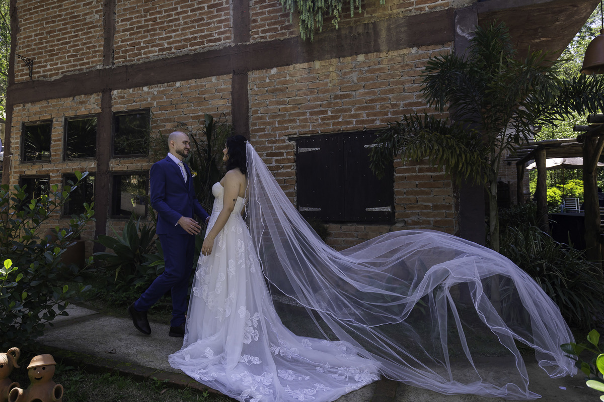 Foto clássica de casamento, que mostra o véu da noiva voando.