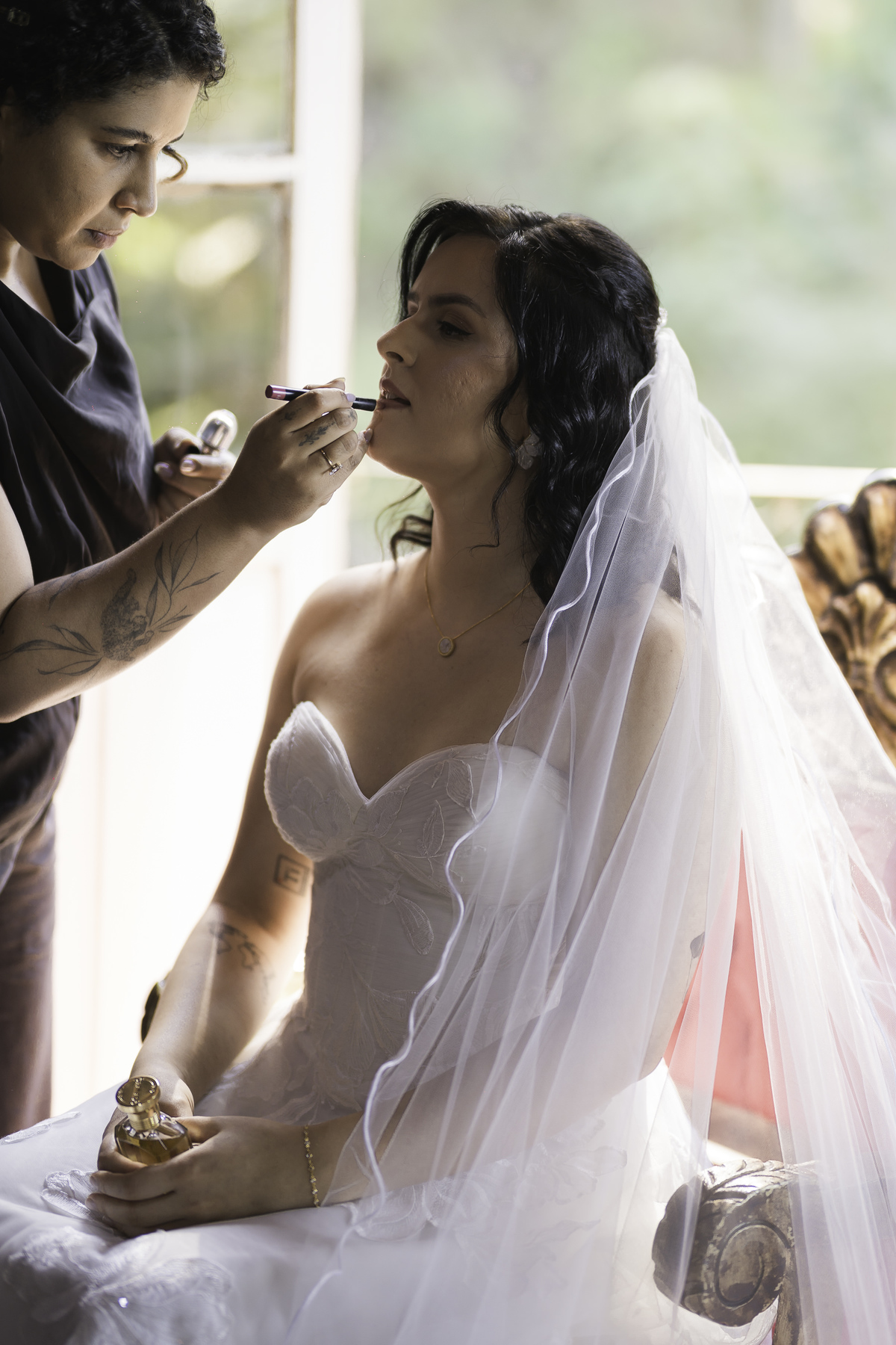 Makeup de bride, nova retocando o seu batom, para se direcionar a cerimônia.