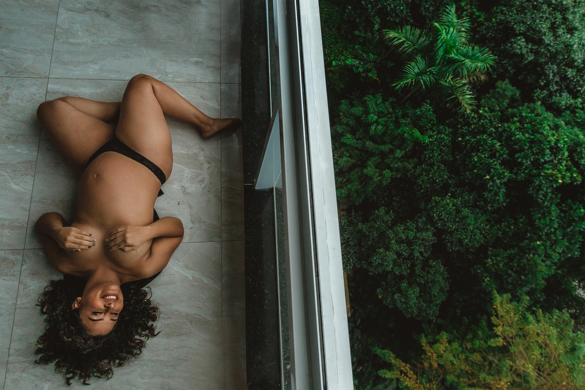 ensaio-feminino-gestante-vista-mar-janela-luz-natural-praia-nu