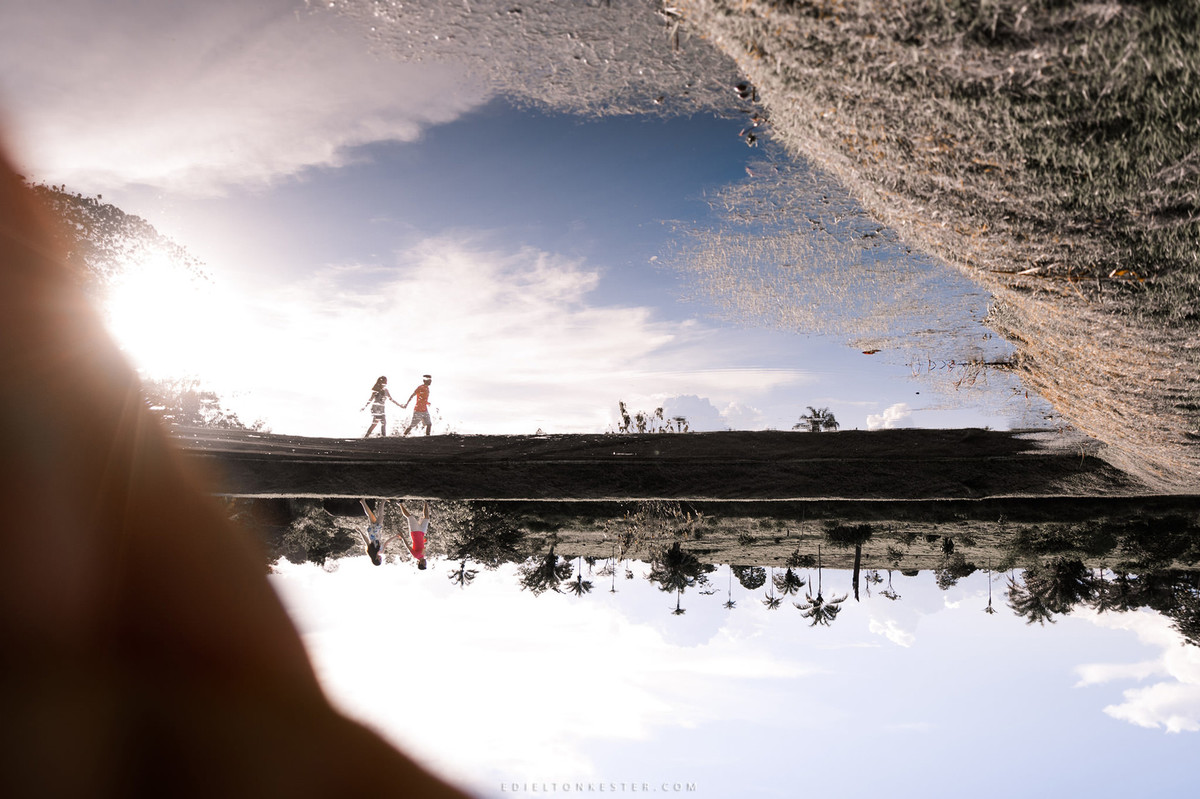 noivos correndo ao entardecer de maos dadas após o casamento