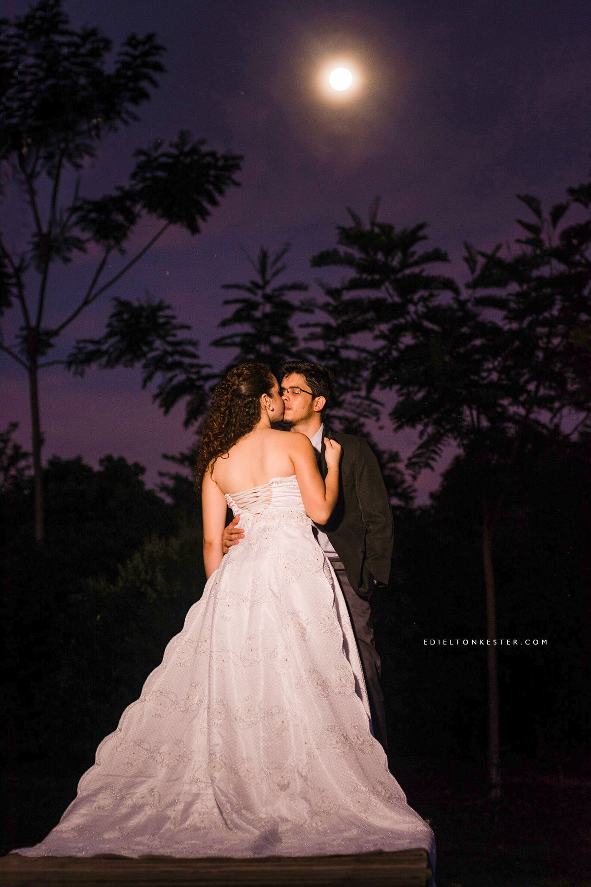 noivos se beijando após o casamento a luz da lua