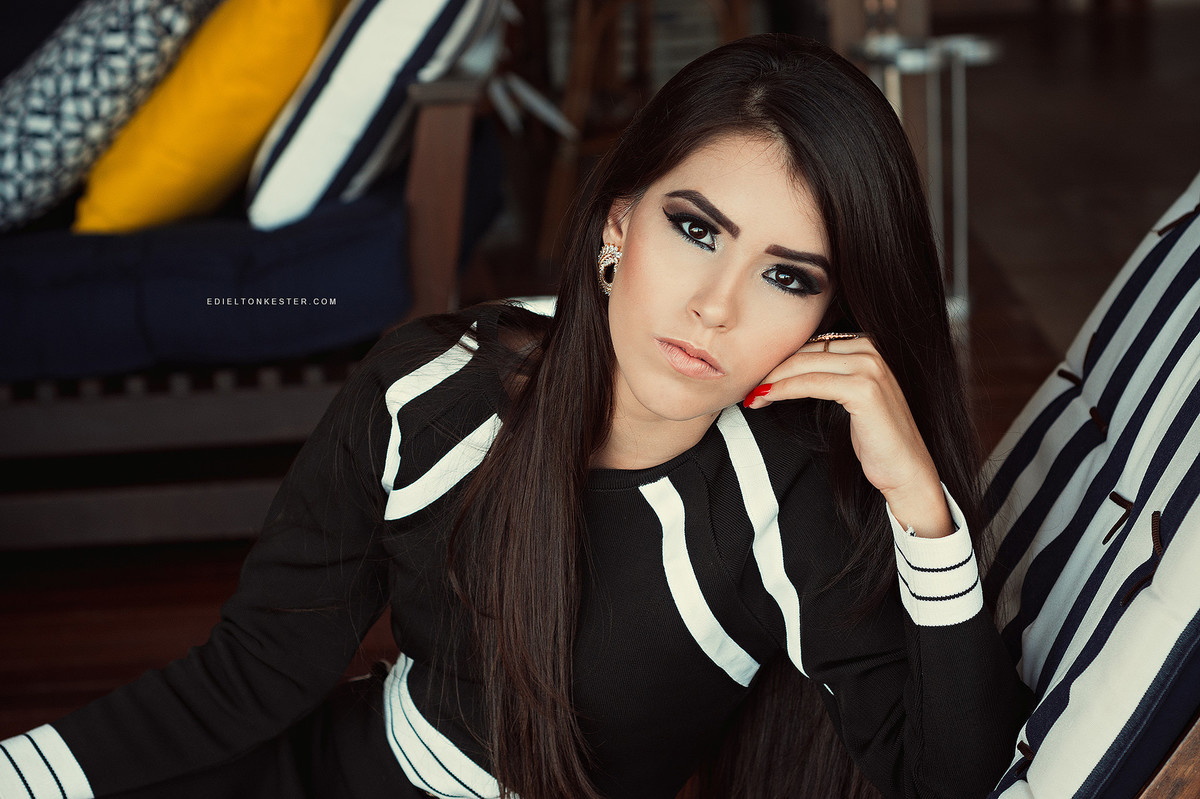 menina apoiando o rosto sobre a mao enquanto se inclina