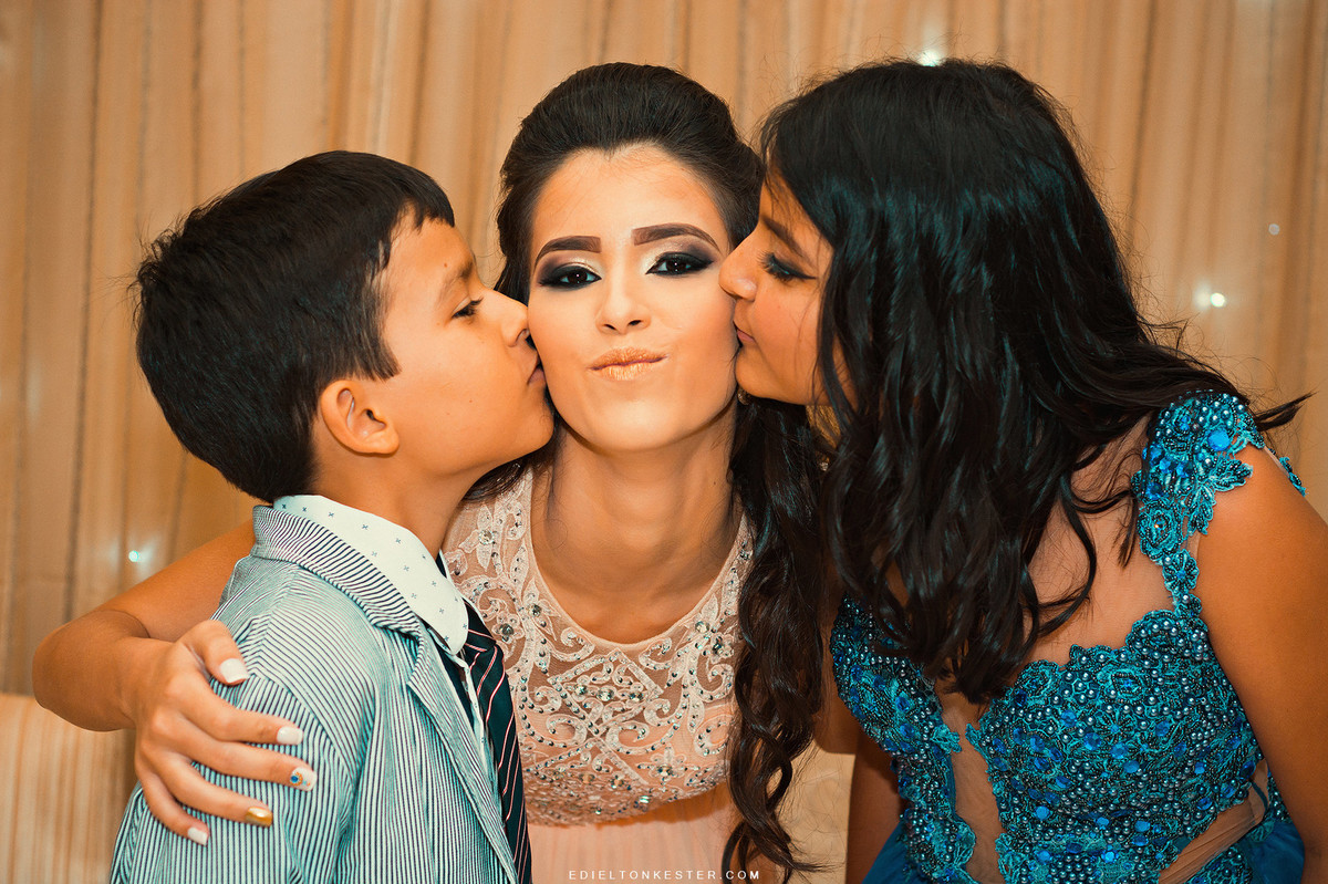 irmaos beijando a irma no seu aniversário de 15 anos